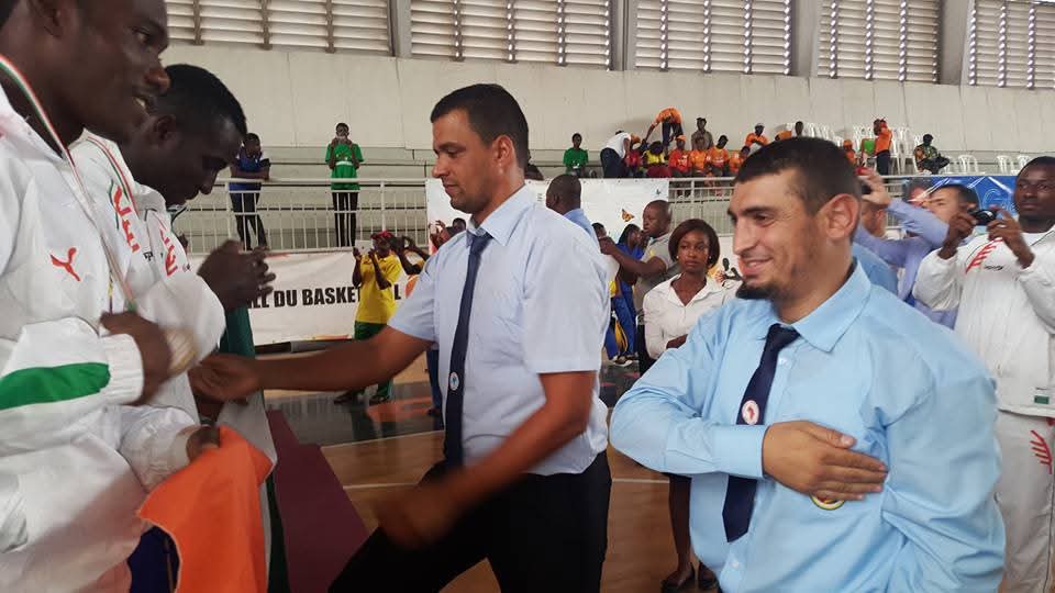 Redouane officiating and draping the flag at a continental championship in Côte d'Ivoire